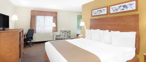 A hotel room with a large bed, a desk with a TV, a chair, and two lamps.