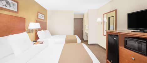 A hotel room with two beds, a television, a refrigerator, and a microwave.