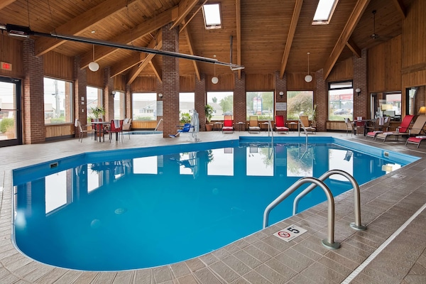 Una piscina techada, sillones reclinables de piscina