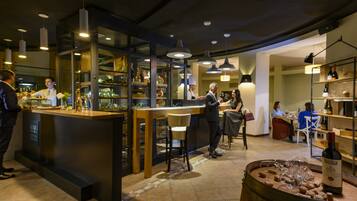 A restaurant interior with a bar area, seating, and a wine display.