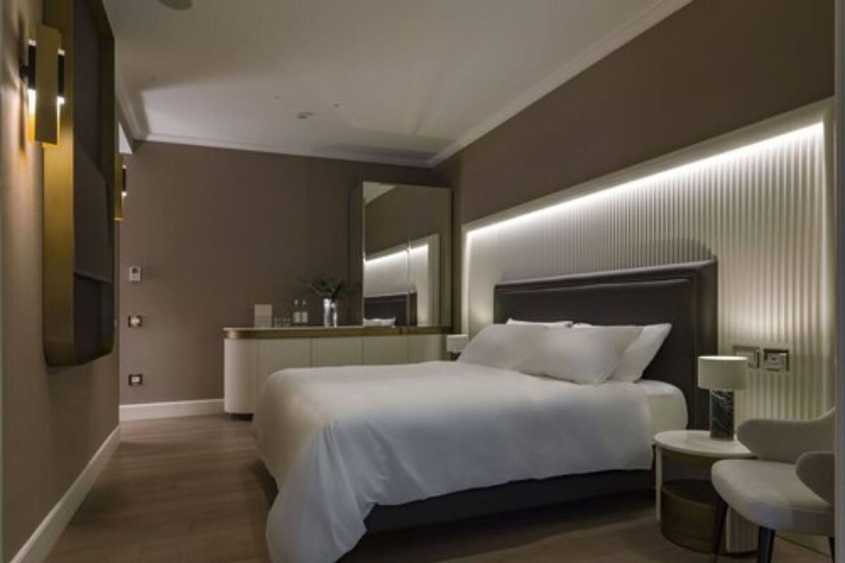 Ein modernes Hotelzimmer mit einem großen Bett, einem Nachttisch und einer kleinen Sitzecke.