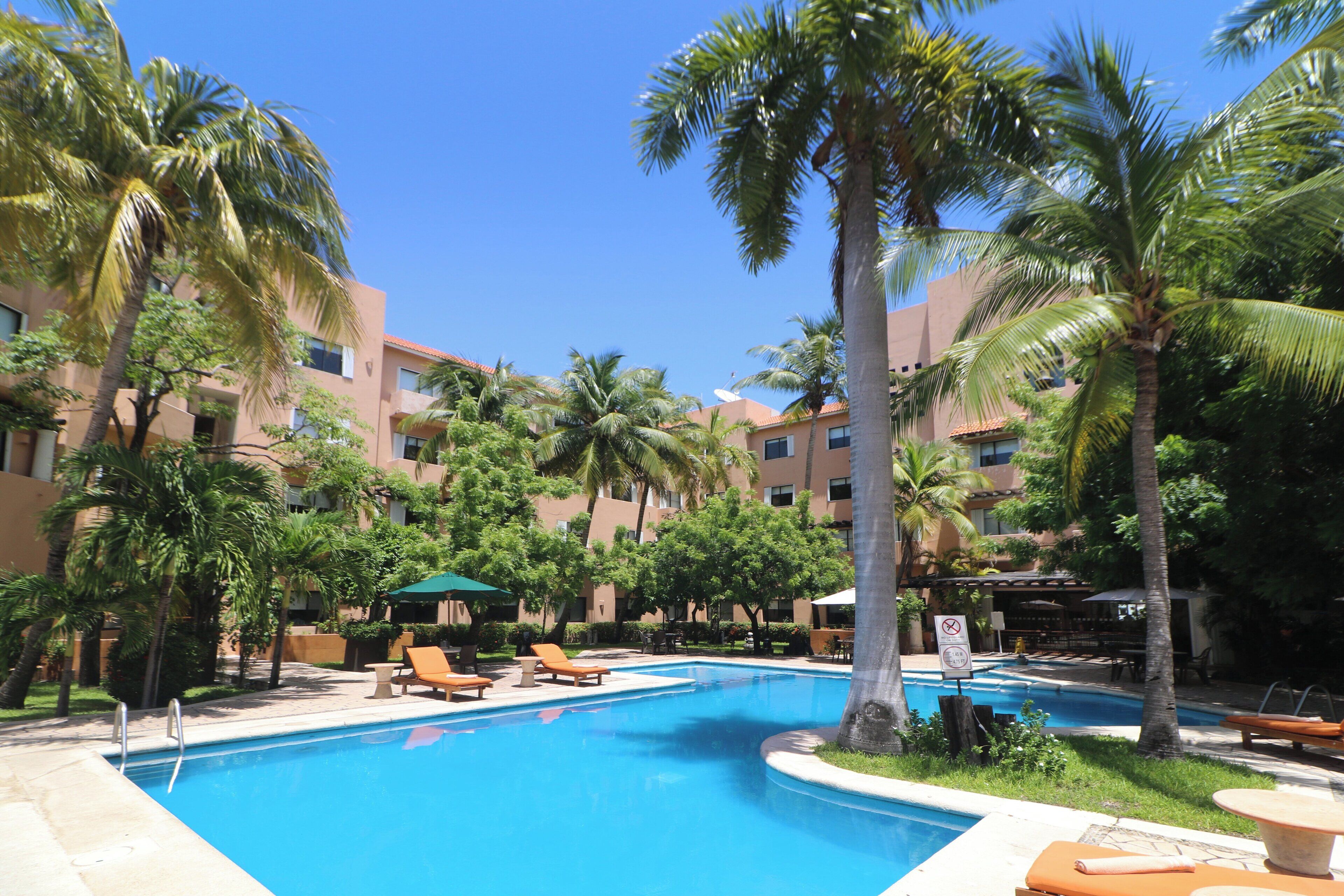 Alberca al aire libre y camastros 