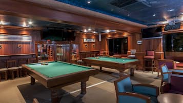 Enjoy a game of pool in our classic billiards room, featuring two tables and comfortable seating areas.