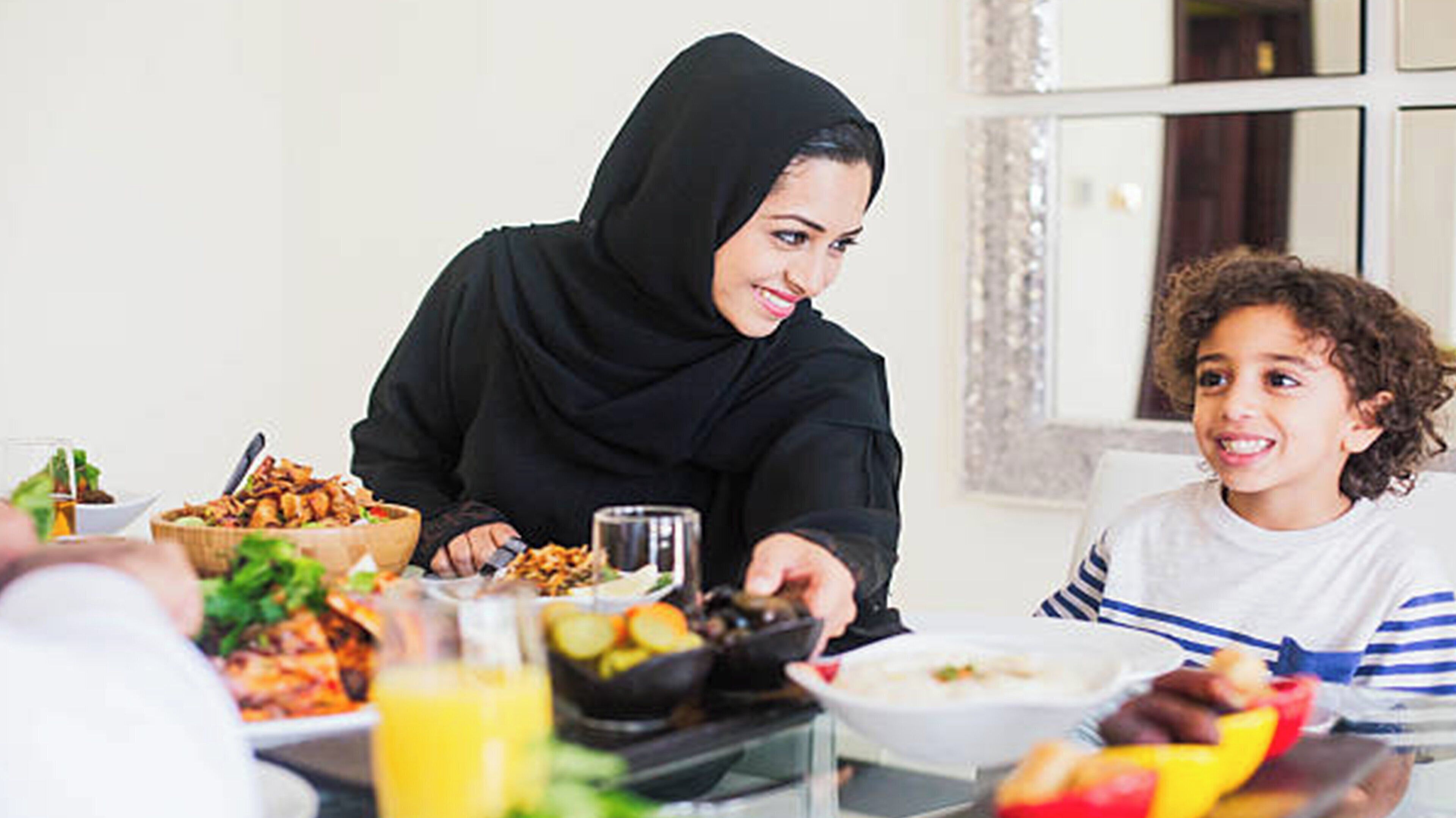 A dining table with various dishes and a glass of juice.