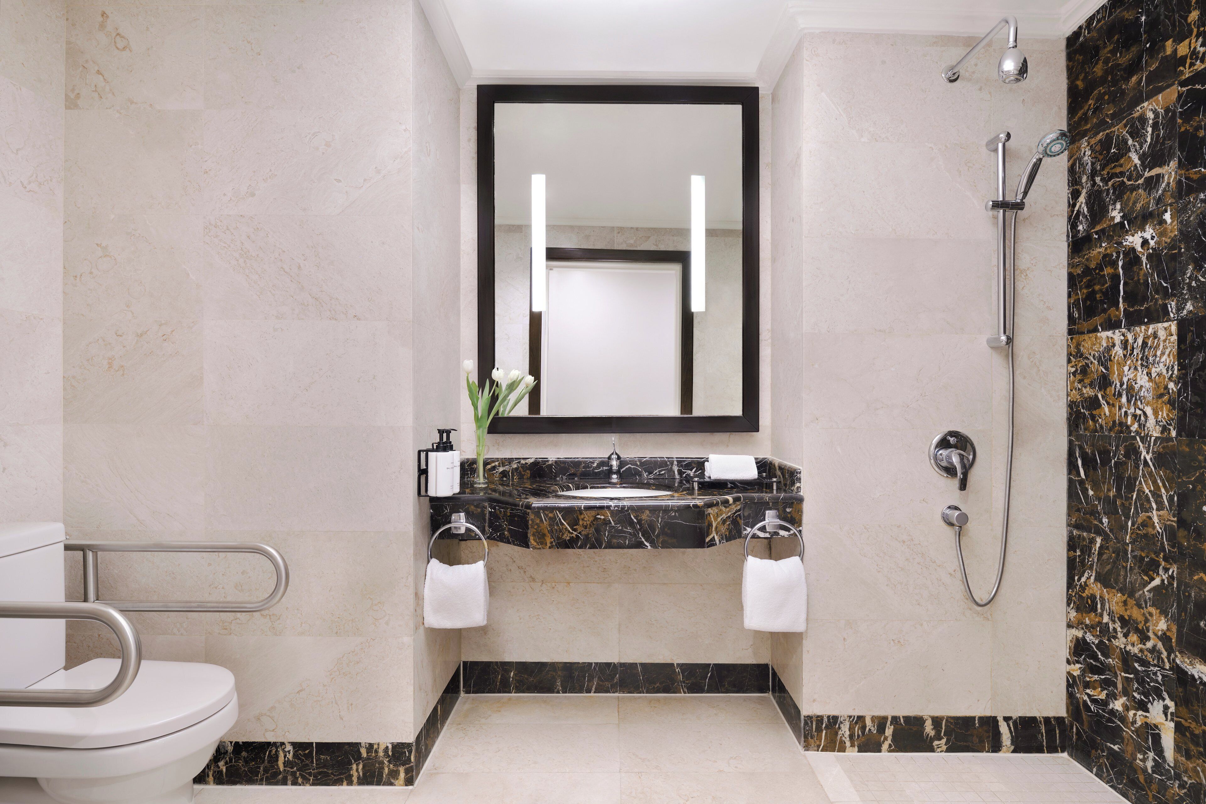 A bathroom with a toilet, sink, and shower.