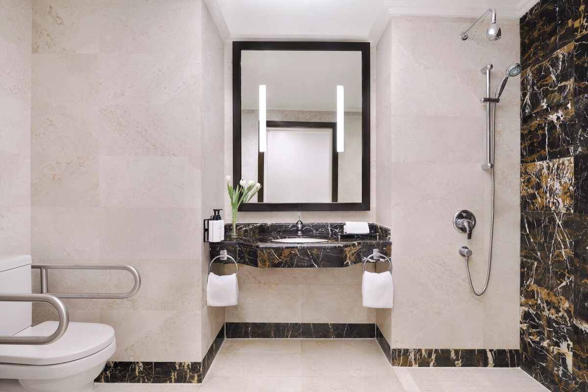 Een badkamer met toilet, wastafel en douche.