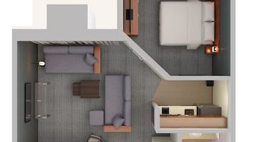 Distribución moderna de una habitación de hotel con cama, sofá y una pequeña cocina.