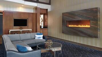 Una sala de estar moderna con un sofá, una mesita de centro y una chimenea empotrada.