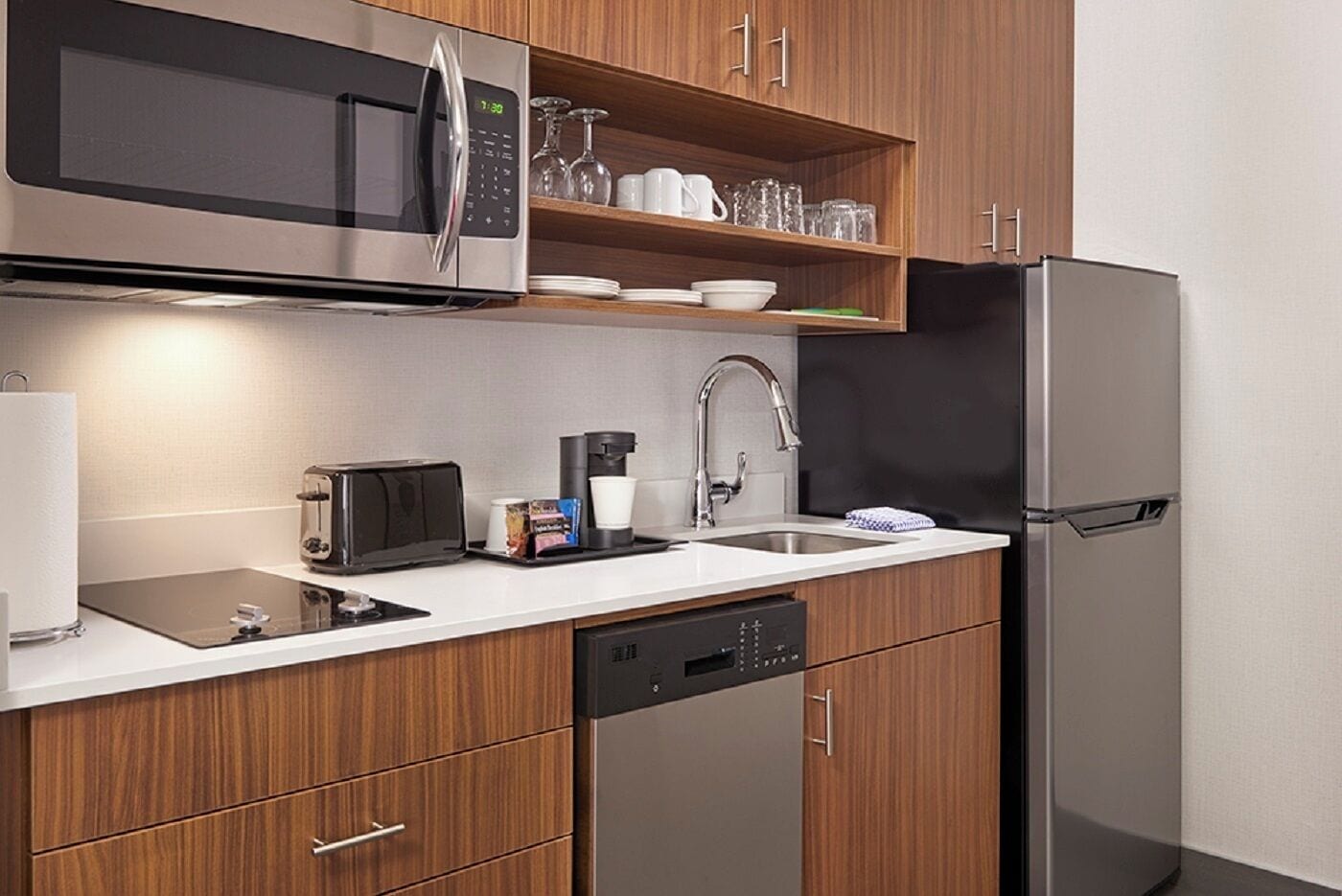 Una cocina moderna con electrodomésticos de acero inoxidable, cafetera y escurreplatos.