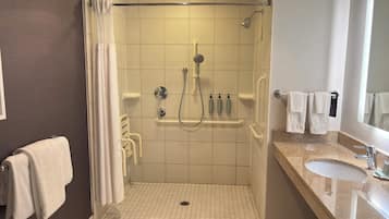 A modern bathroom with a shower, a vanity with a sink, and a mirror.