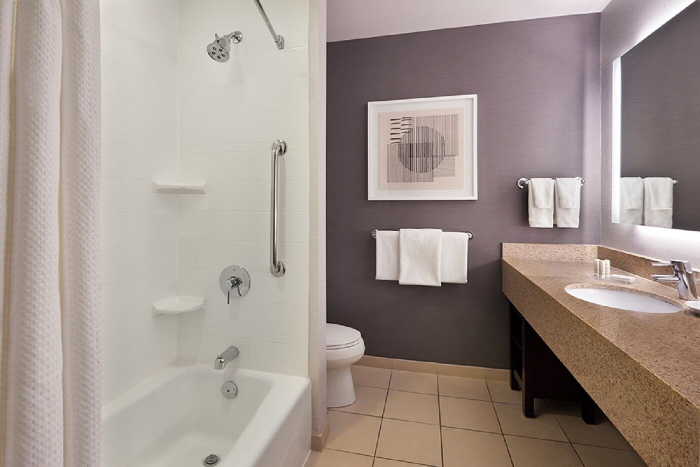 A bathroom with a bathtub, a shower, a toilet, a sink, and a towel rack.