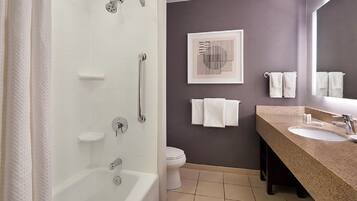 A bathroom with a bathtub, a shower, a toilet, a sink, and a towel rack.