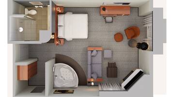 A compact hotel room with a bed, a sitting area with a sofa and armchairs, a small desk, a bathroom, and a shower area.