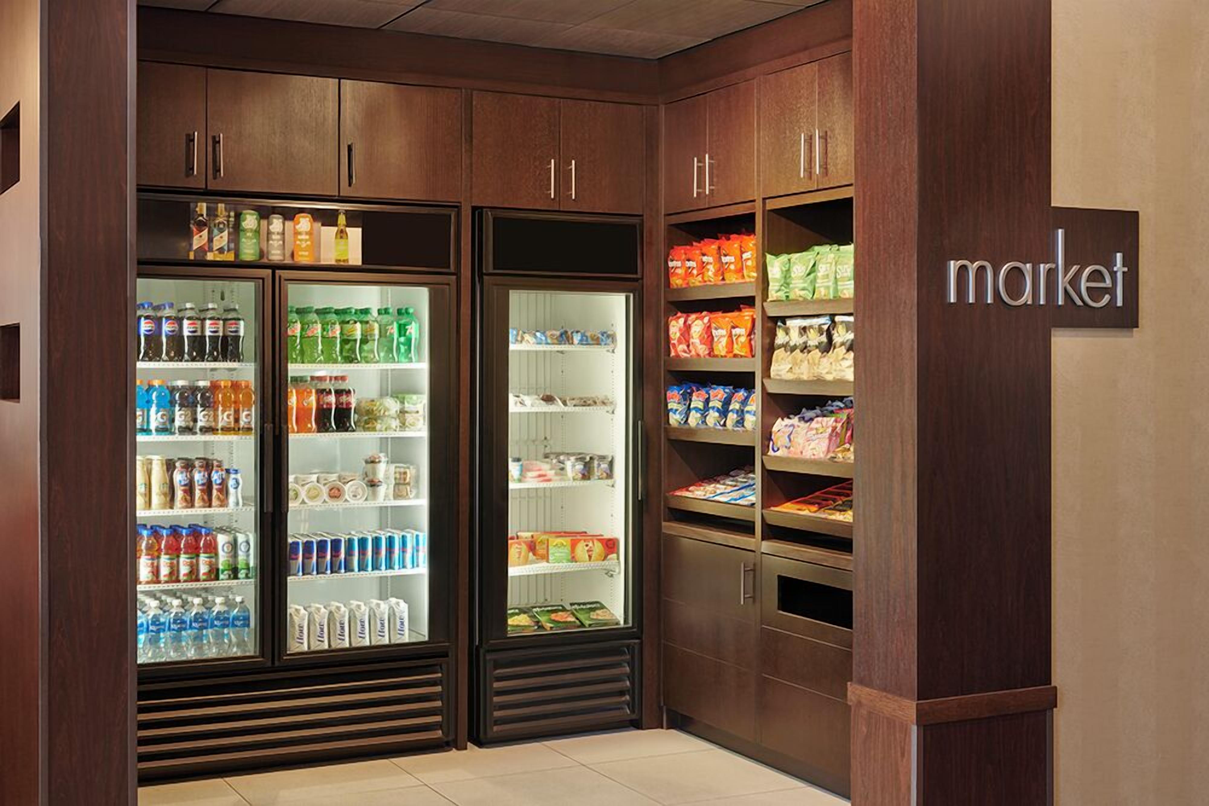 A refrigerated beverage display in a store with a 'market' sign.