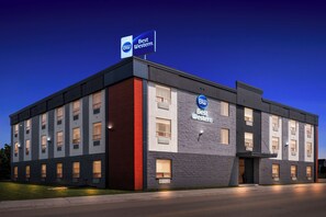 A Best Western hotel with a modern design, featuring a prominent sign, multiple windows, and a well-lit facade.