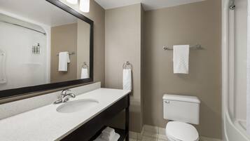 A bathroom with a white sink, a mirror, a toilet, and a towel rack.