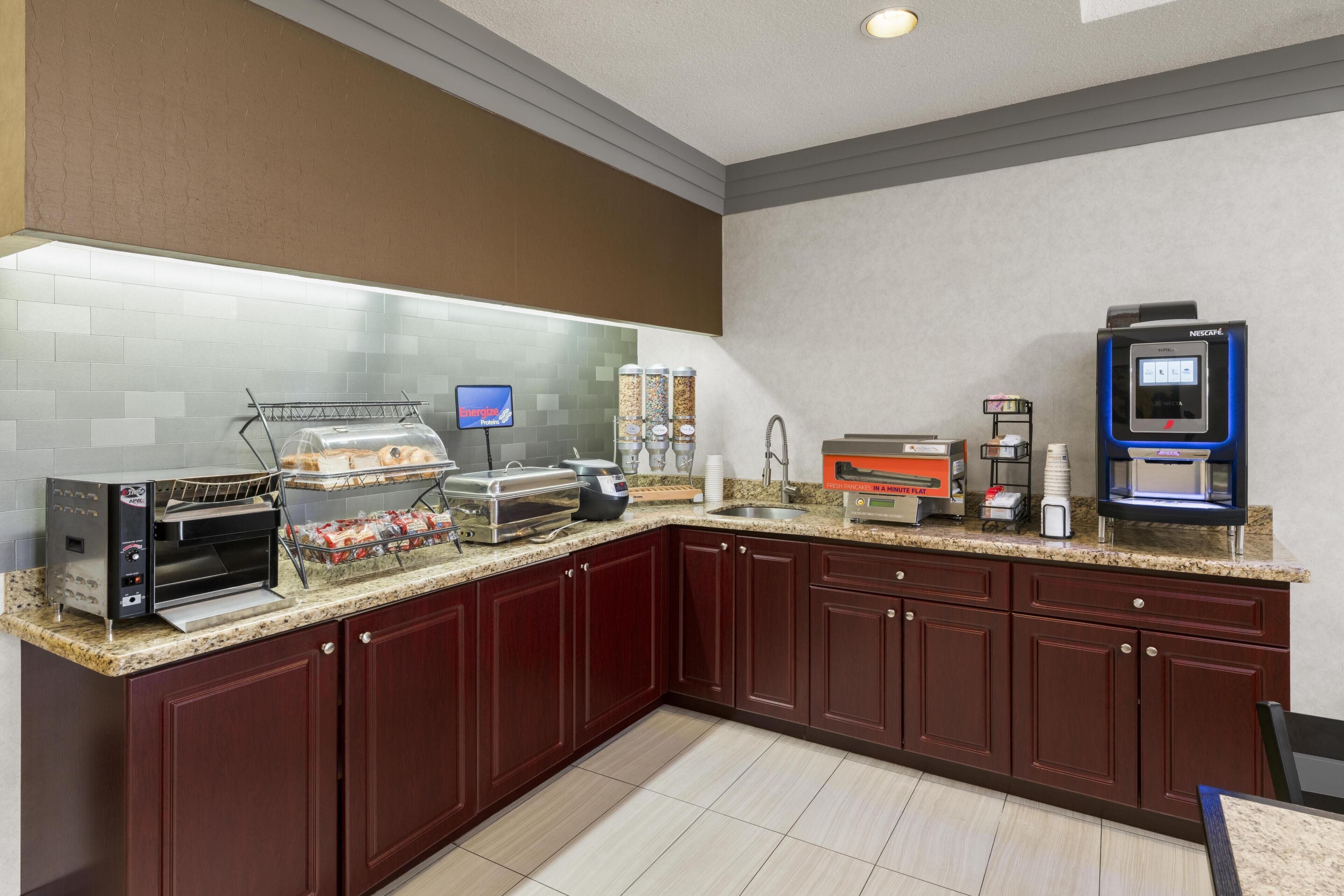 Ett modernt kök med en kaffemaskin, en brödrost och en matutdelare.