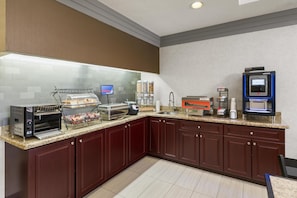 A modern kitchen with a coffee machine, a toaster, and a food dispenser. - Best Western Swan Castle Inn (Cochrane)