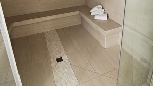 A modern bathroom with a glass shower enclosure, a bench, and a towel rack. - Best Western Swan Castle Inn (Cochrane)