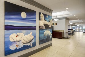 A hotel corridor with artwork depicting swans, a polar bear, and a moonlit night scene. - Best Western Swan Castle Inn (Cochrane)