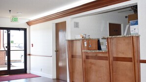 Un hall de hotel con un letrero de salida, una recepción y una puerta que indica "Privado".
