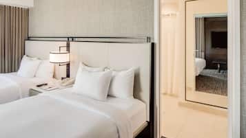 Une chambre d’hôtel avec deux lits, une table de chevet avec une lampe, un téléphone et un miroir.