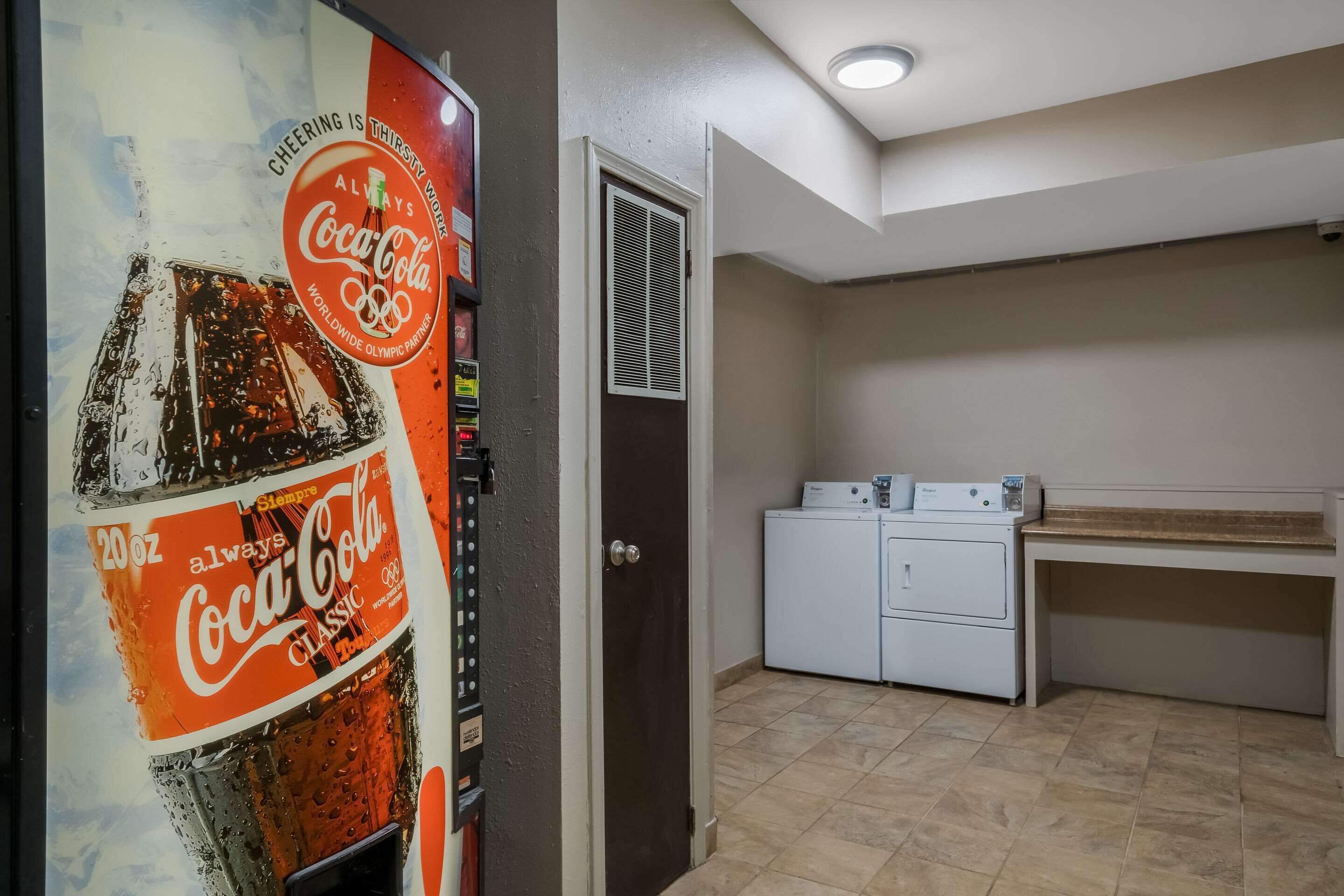 Une pièce équipée d’un distributeur automatique, d’une porte et d’un lave-linge.