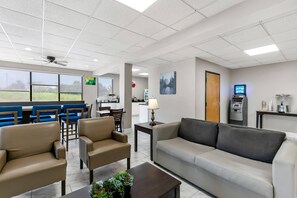 A hotel lobby with seating, an ATM, and a view of the outdoors. - Quality Inn Jefferson at I-85 (Jefferson)
