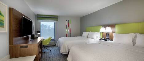 A hotel room with two beds, a desk, a television, and a window with a view.