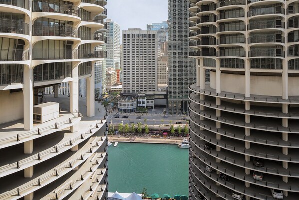 A high-rise building with multiple balconies and a view of a marina below.
