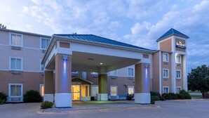 A hotel with a covered entrance, multiple windows, and a sign indicating it is a Baymont location. - Baymont by Wyndham Kirksville University Area (Kirksville)