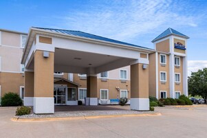 Un hotel con vestíbulo cubierto, varios pisos y una señalización llamativa.