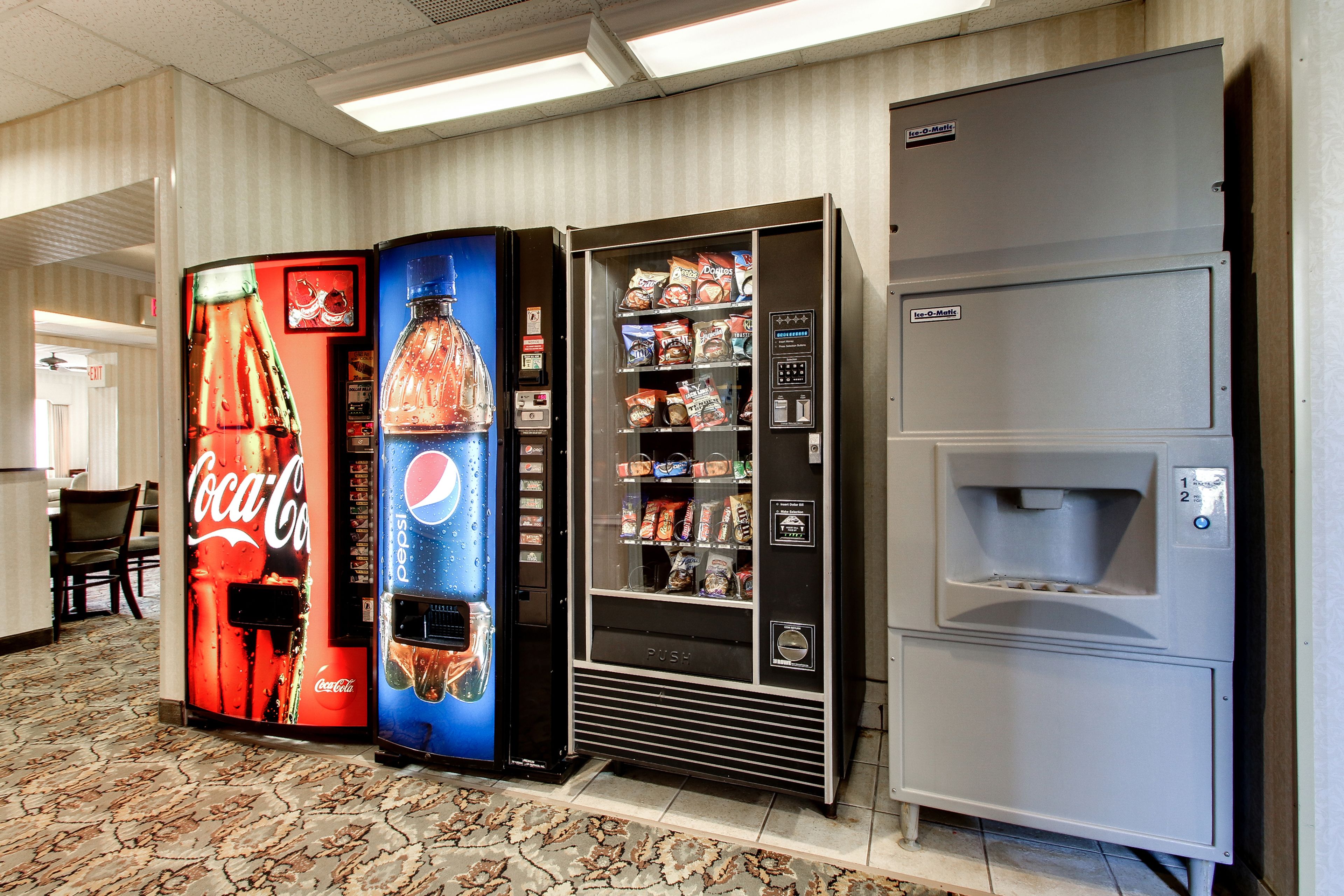 A vending machine area with Coca-Cola and Pepsi machines, a snack vending machine, and a water dispenser.