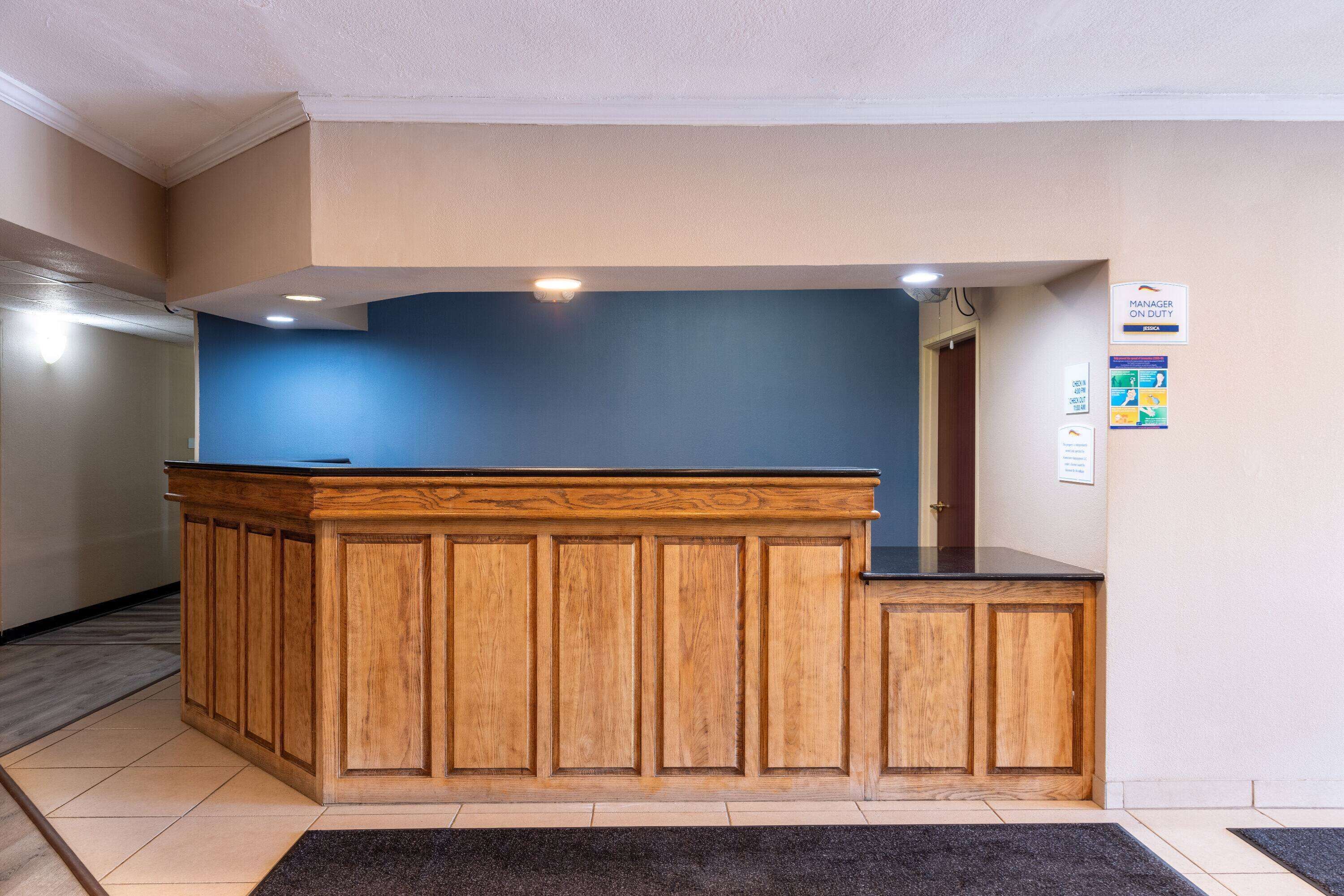 A reception desk with a wooden finish and a blue accent wall.