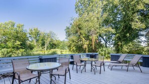 A deck with outdoor furniture including chairs and a table, surrounded by trees and a blue fence. - Baymont by Wyndham Kirksville University Area (Kirksville)