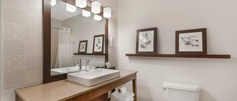 A bathroom with a sink, mirror, and toilet.