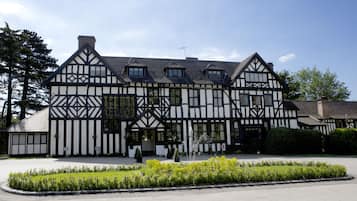 Traditional inn with a symmetrical facade, central entrance, and well-maintained garden.