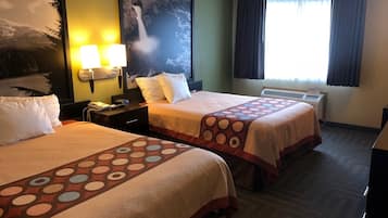 A hotel room with two beds, a nightstand, a lamp, a painting, and a window with curtains.