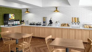 Une cuisine moderne avec des meubles en bois, un mur de briques blanches et un coin café.