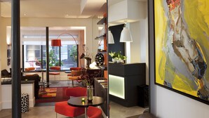 Um interior moderno com balcão de recepção, área de estar e uma grande pintura abstrata.