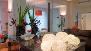 Uma sala de estar moderna com uma mesa de centro de mármore, esferas de vidro decorativas e um sofá.