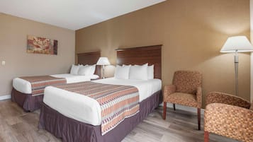 Una habitación de hotel con dos camas, una silla y una lámpara.