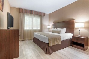 A hotel room with a bed, bedside lamps, a TV, and a desk. - Best Western Circus City Inn (Peru)