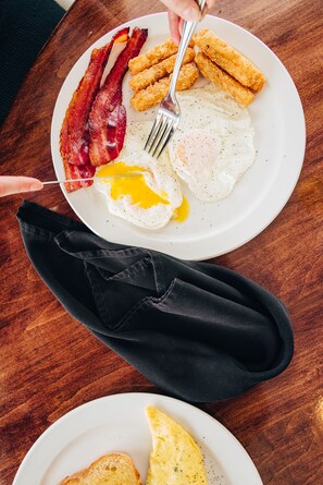 Savor a hearty breakfast with bacon, eggs, and chicken cutlets.