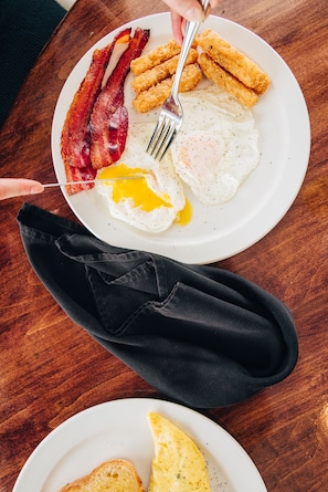 Savor a hearty breakfast with bacon, eggs, and chicken cutlets.