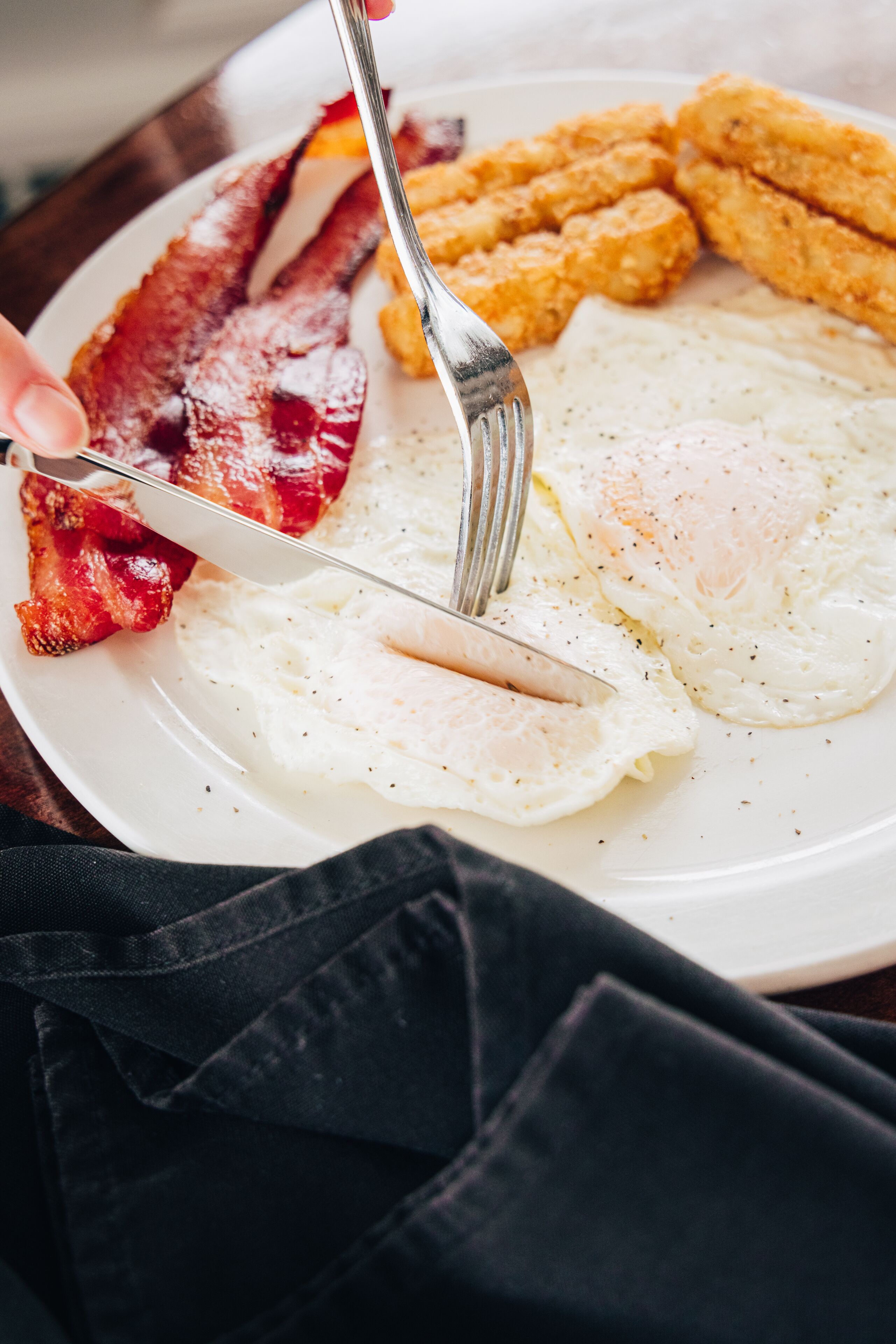A breakfast plate with fried eggs, bacon, and hash browns.