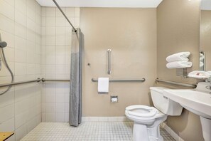A bathroom with a shower, toilet, and sink.