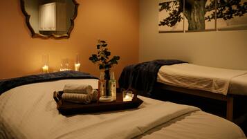 Experience a serene retreat with two single beds, a mirror, and a beautiful floral arrangement.