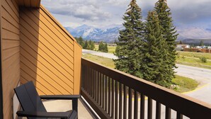 A balcony with a view of mountains and a road.