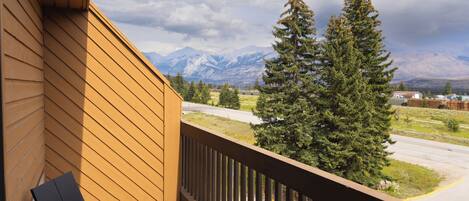 A balcony with a view of mountains and a road.